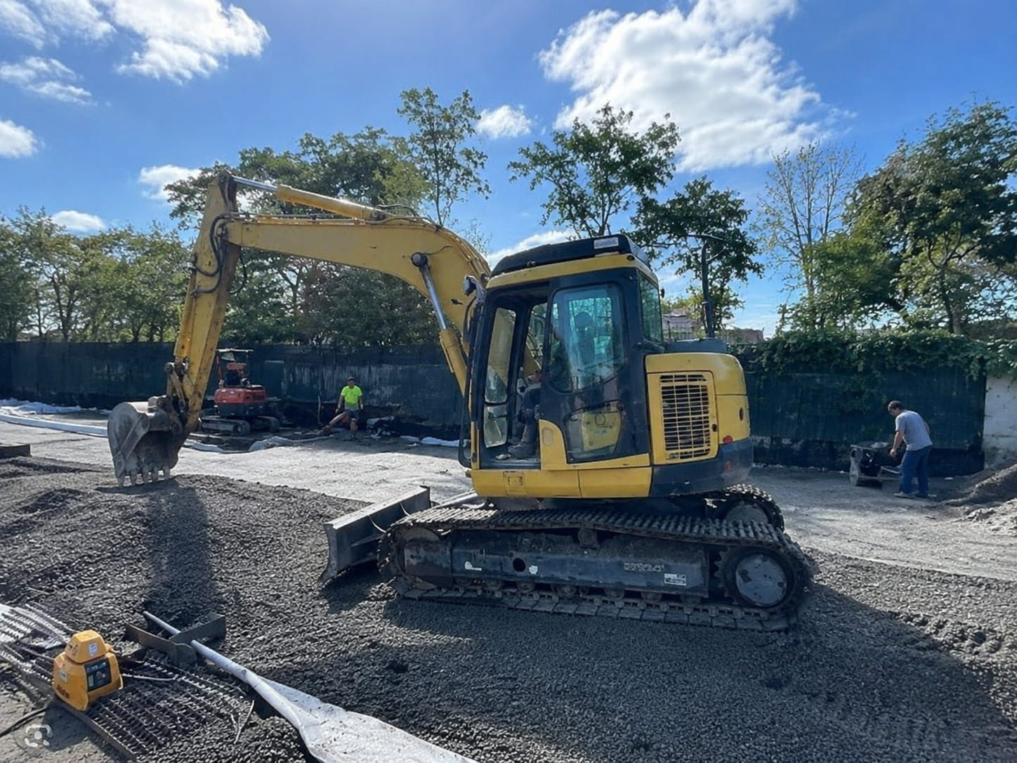 Tracked excavator standing on a compacted hardfill pad on a Christchurch site