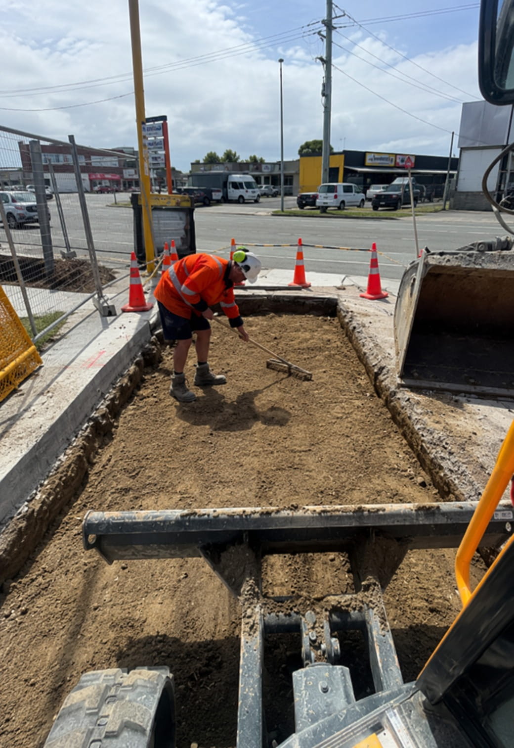 Christchurch civil crew raking a boxed-out sub-base level beside a roadway